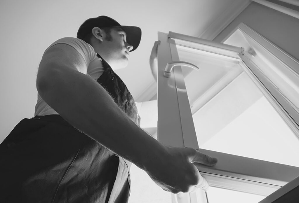 Professional handyman installing window at home.